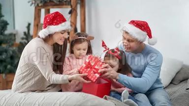 惊艳幸福一家人在喜庆的服装中一起打开礼盒庆祝圣诞节